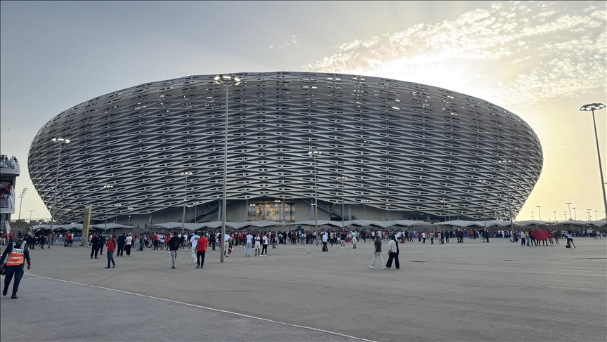 Exterior of Prince Moulay Abdellah Stadium in Rabat featuring the golden shell facade and eucalyptus trees.